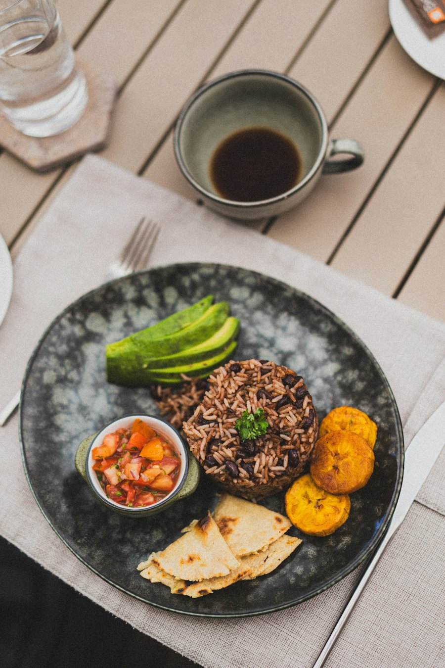 Prato com arroz e feijão, abacate, banana-da-terra e vinagrete
